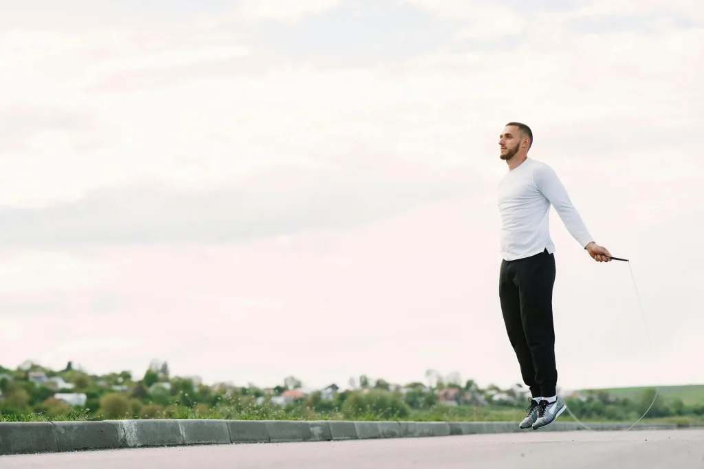 Man skipping with a jump rope outdoors during fitness training