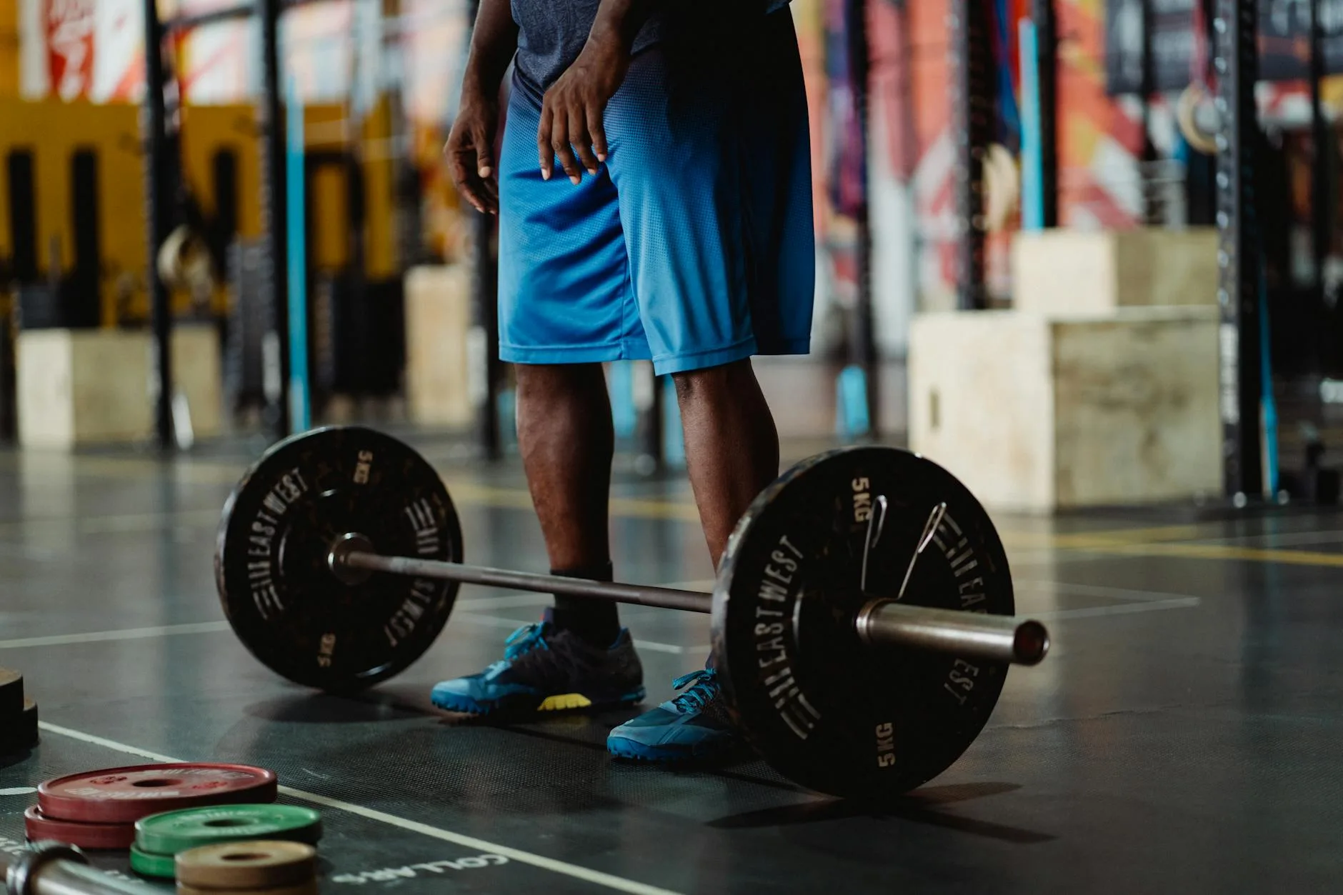 Loaded barbell on gym floor set up for deadlift warm-up training session