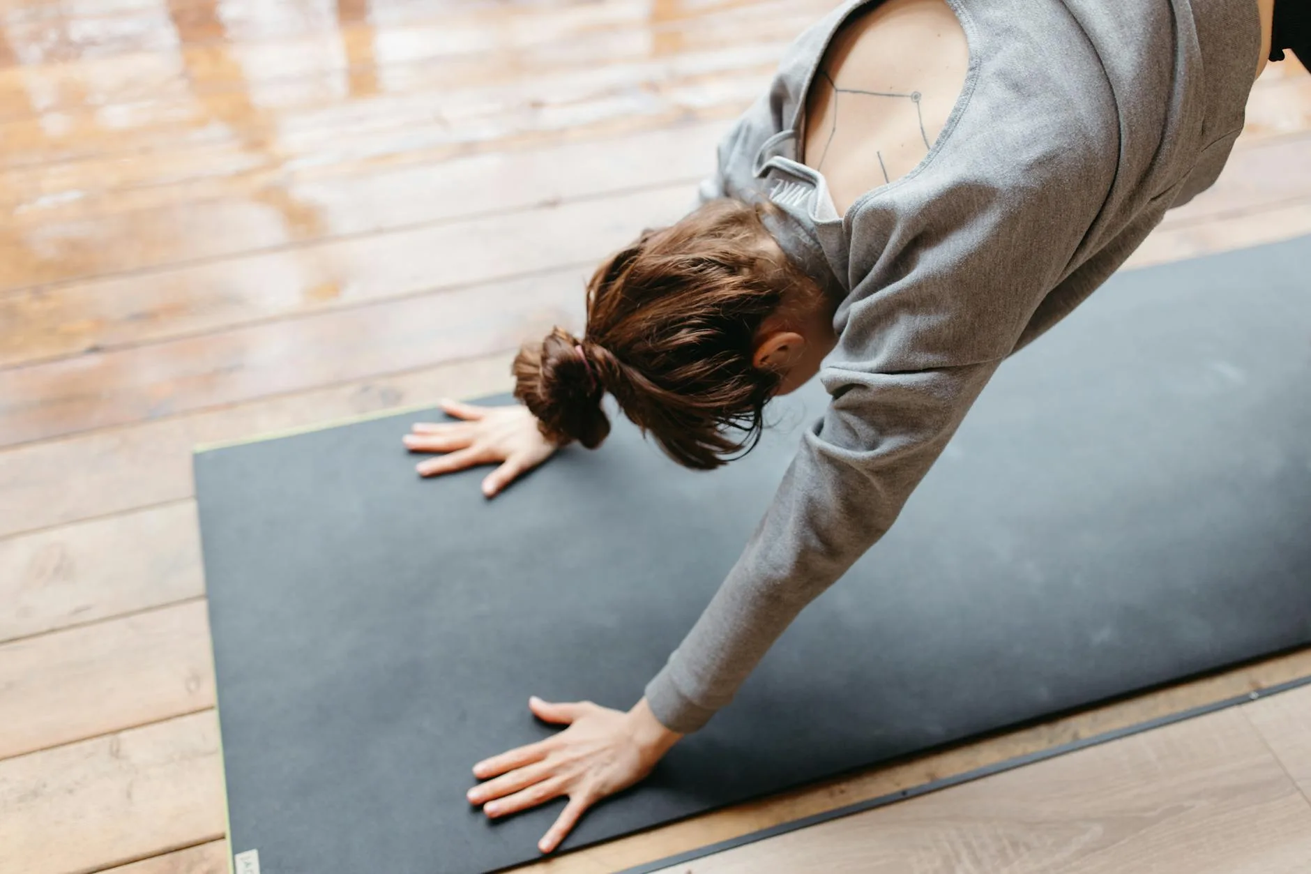 Person in downward-facing dog yoga pose on a mat