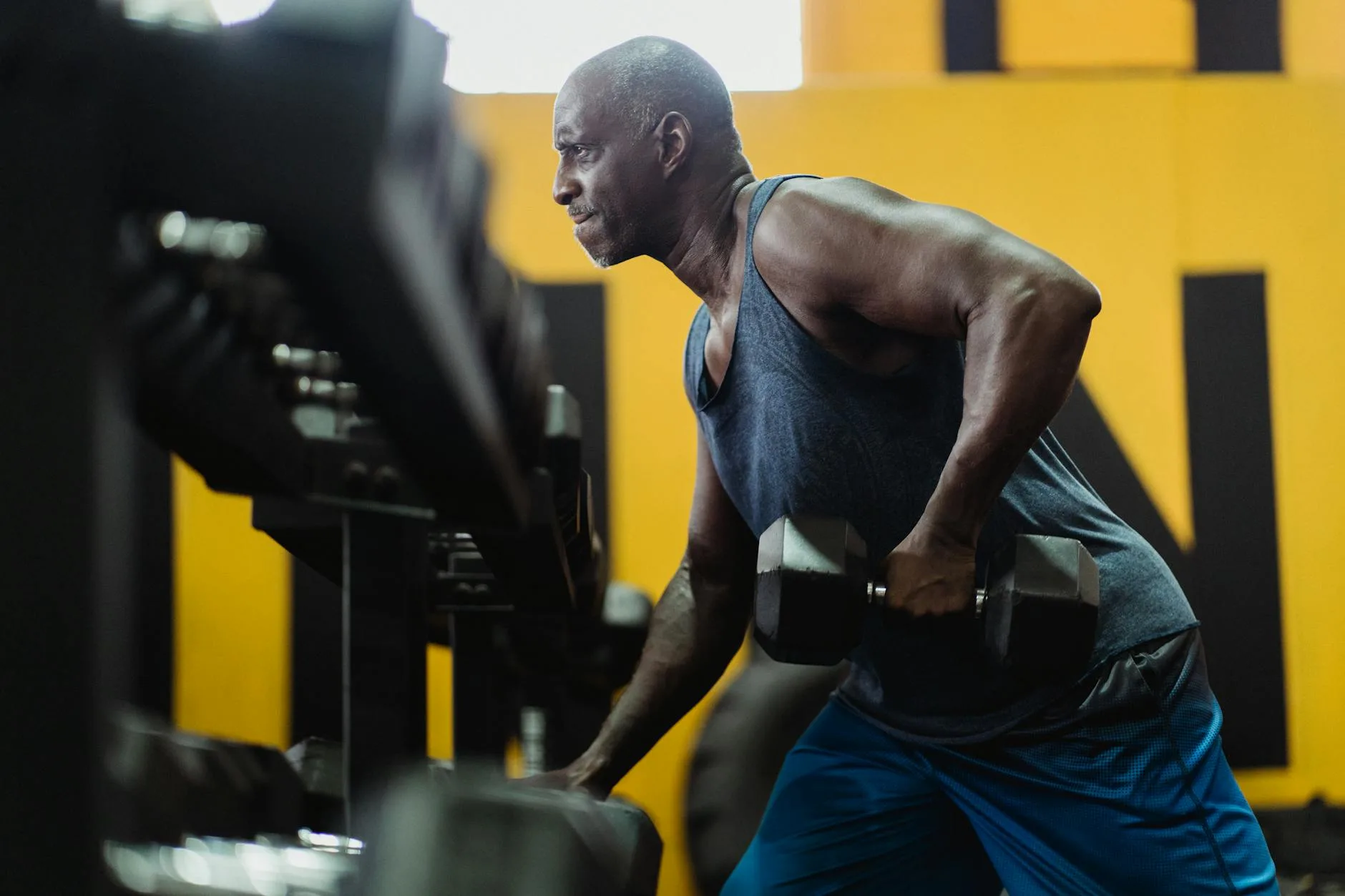 Person performing a bent-over dumbbell row in a gym