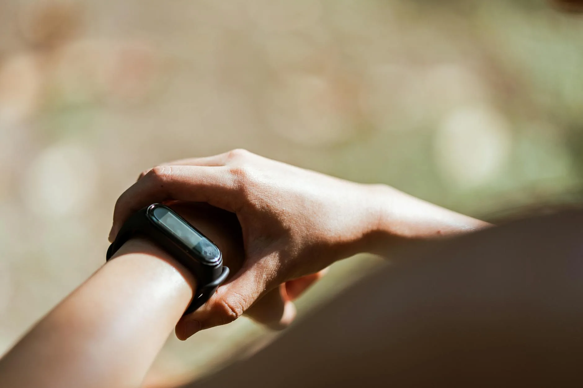 Close-up of person checking fitness tracker on wrist in morning light