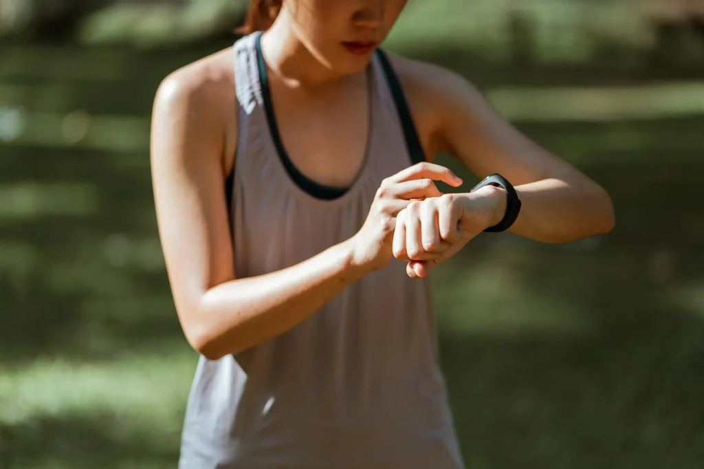 Runner checking fitness smartwatch during outdoor workout