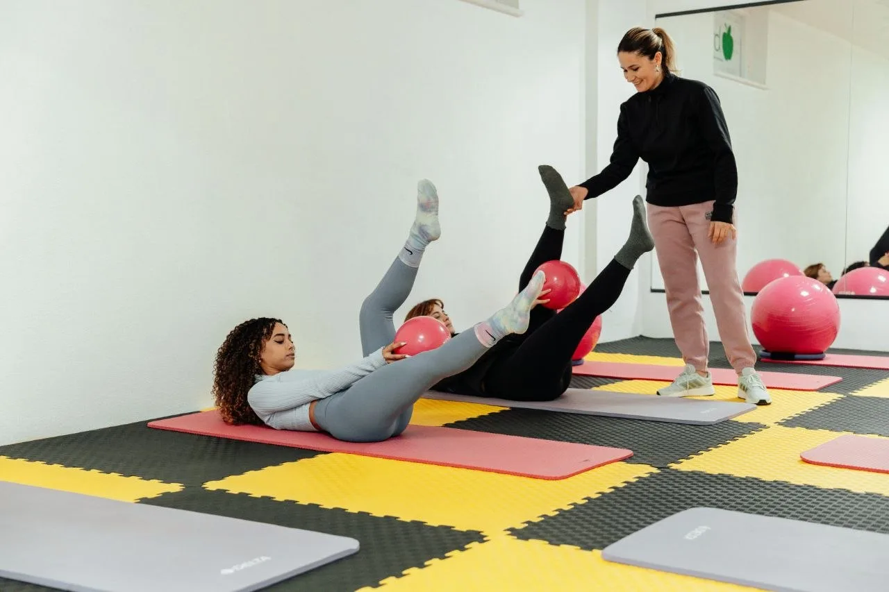 Women exercising on interlocking foam puzzle mats in a Pilates class