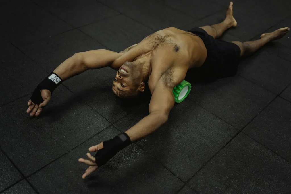 Person using a foam roller on their thigh muscles in a home gym