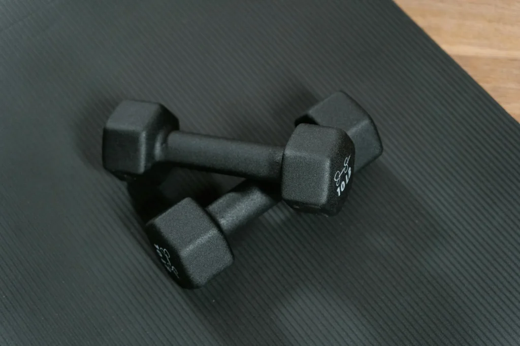Home gym setup with dumbbells and exercise mat in a bright room