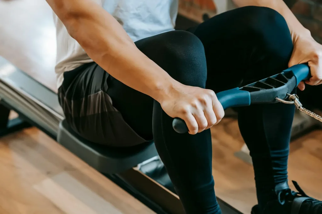 Person working out intensely on a rowing machine in a gym
