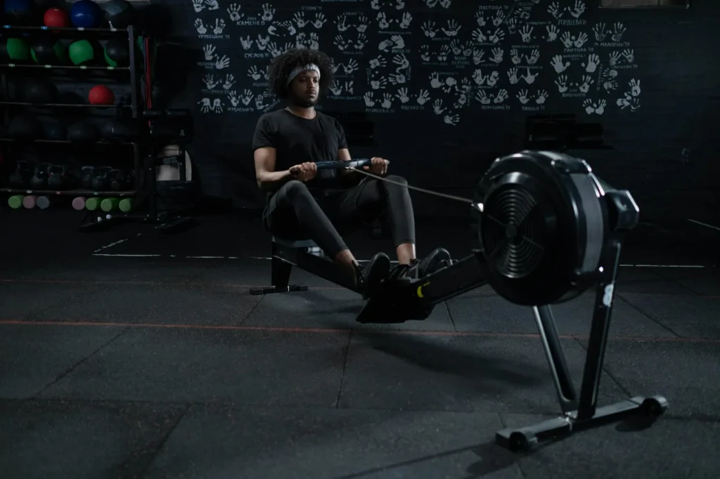 Person using a rowing machine in a home gym setup