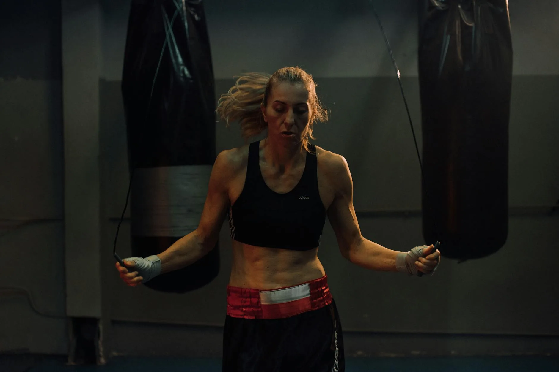 Woman training with a skipping rope in a gym for cardio