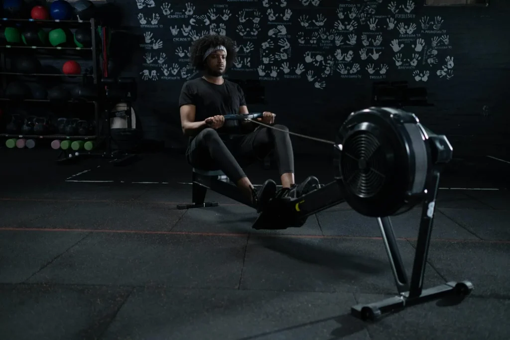 Person using a smart rowing machine during an intense gym workout session