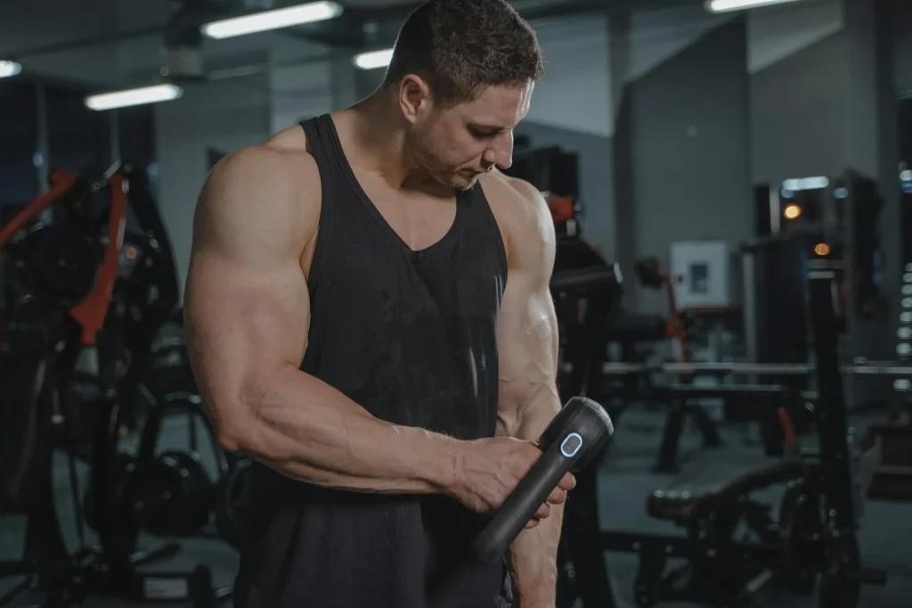 Percussion massage gun being used for muscle recovery