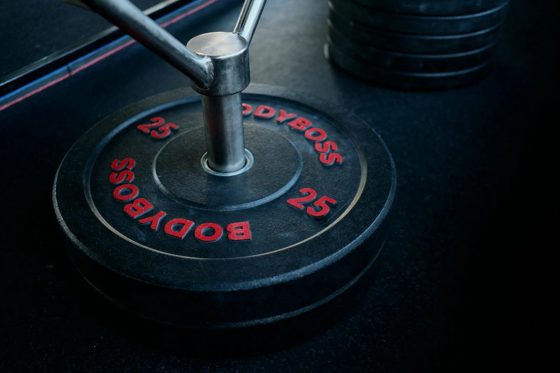Weight plates stacked beside a barbell in a home gym