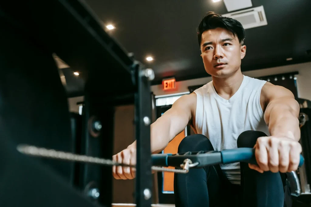 Person using a rowing machine with proper form in a gym