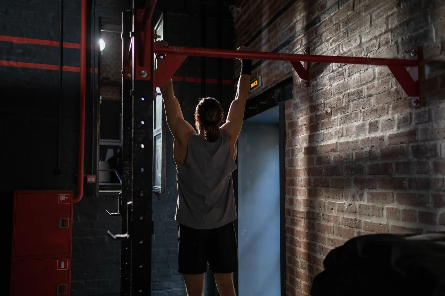Dead hang from a pull up bar to build grip strength for beginners