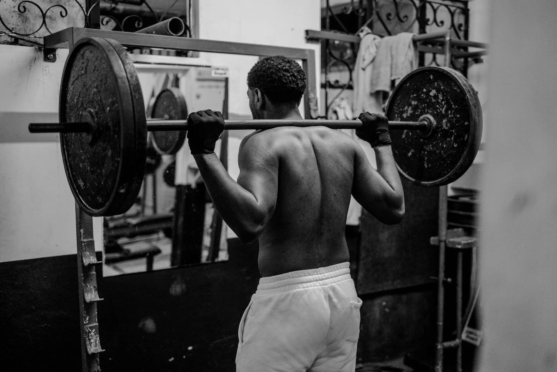 Lifter using a squat rack with a loaded barbell