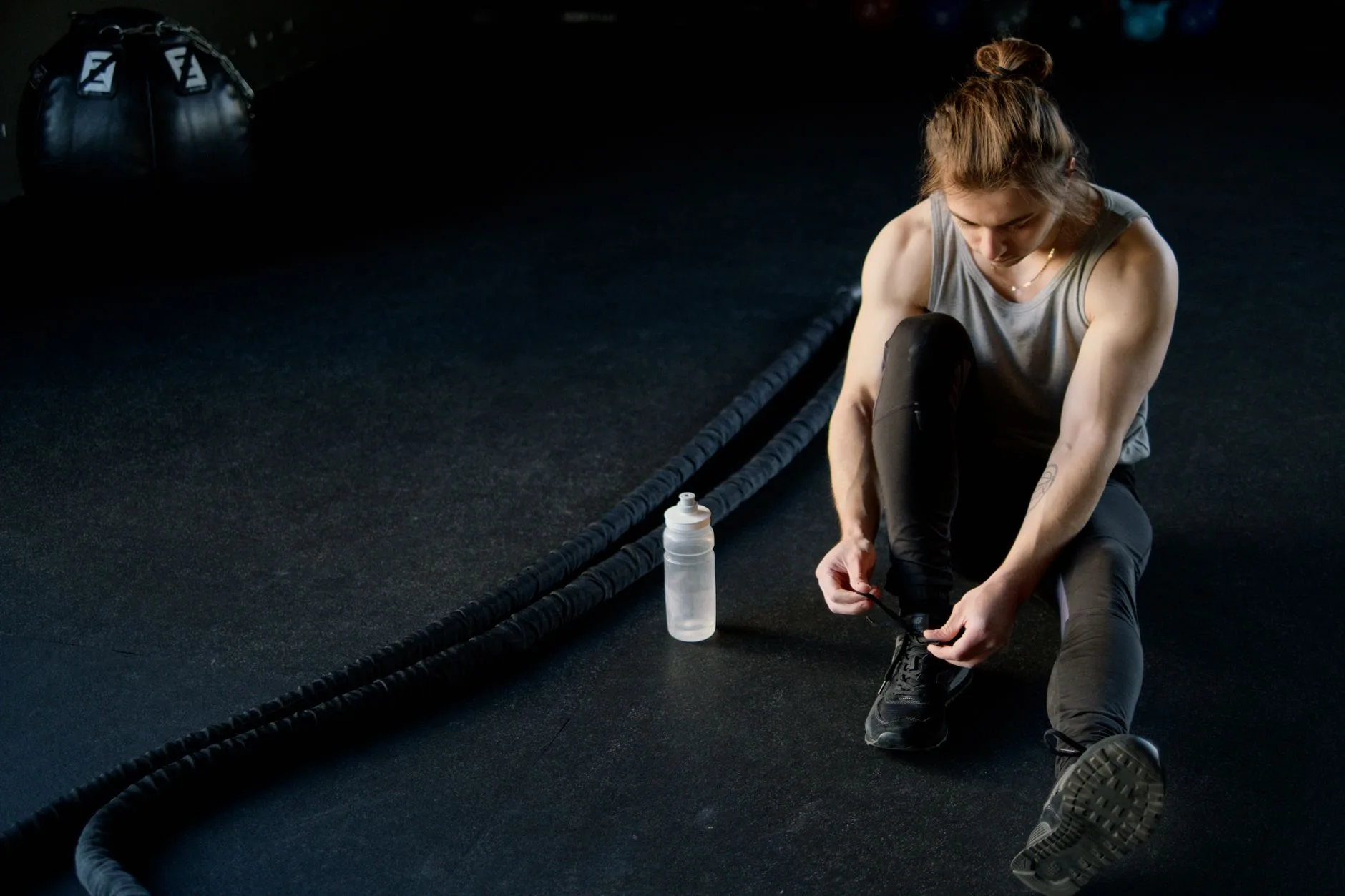 Battle rope anchored on a gym floor with space for waves and slams