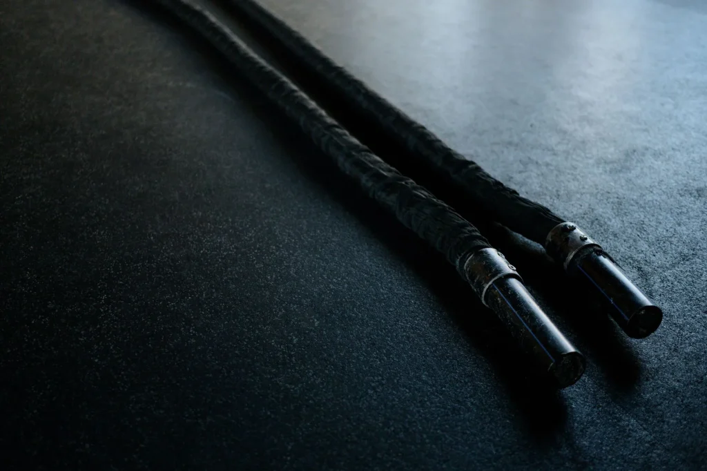 Battle ropes laid out on a gym floor for a home conditioning workout