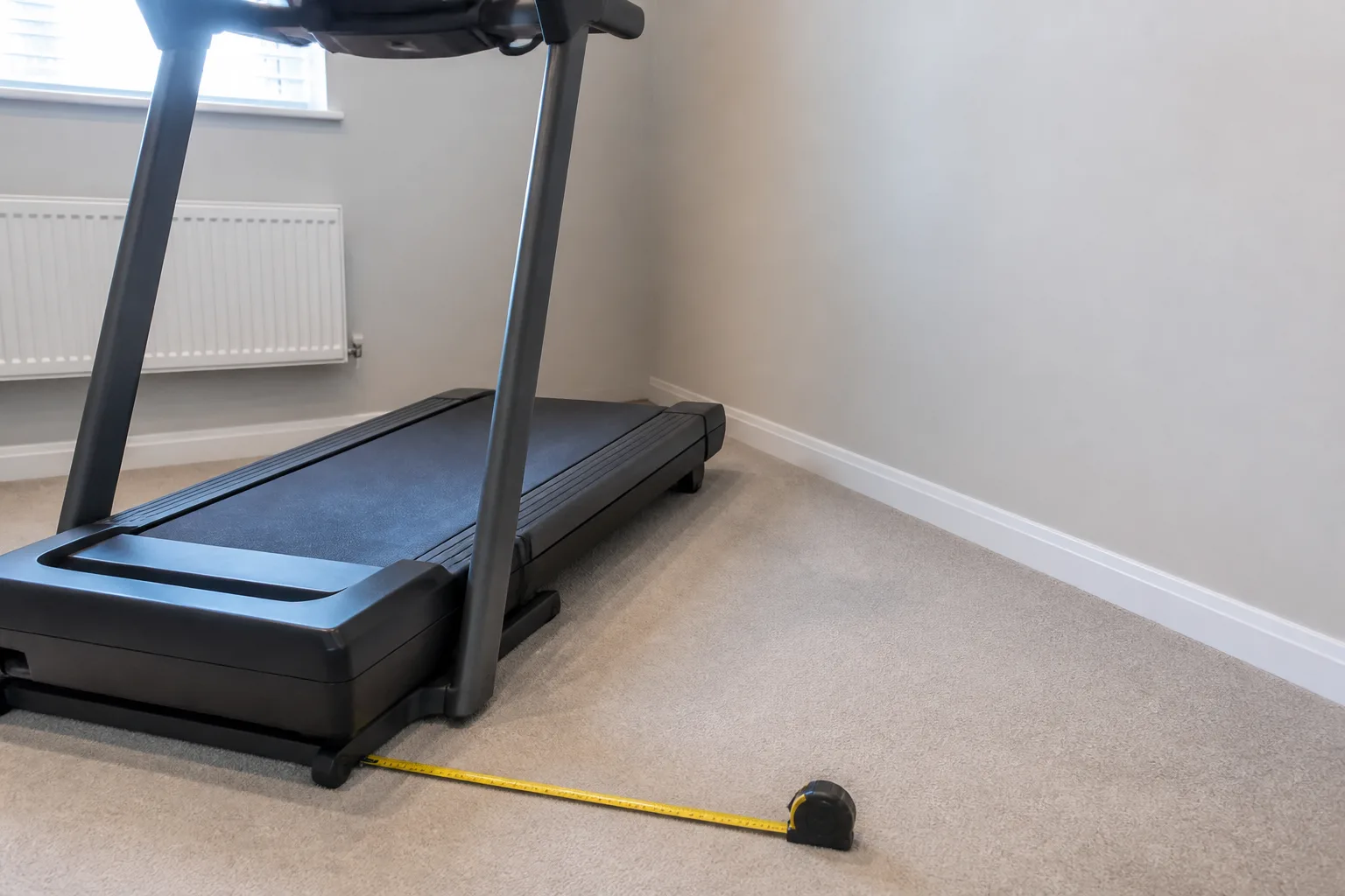 Tape measure beside a treadmill deck with clear space behind the machine